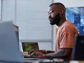Side view of an IT professional working on a PC.