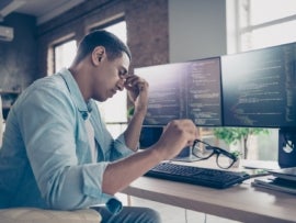 A photo of a stressed IT technician debugging his codes.