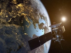 3D rendering of a satellite orbiting the earth with illuminated cities at night