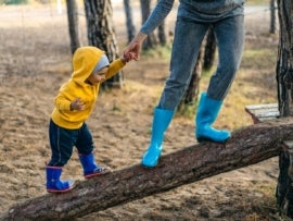 A child and a nanny play at a playground.