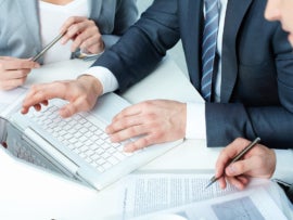 Professionals collaborating together infront of a laptop.