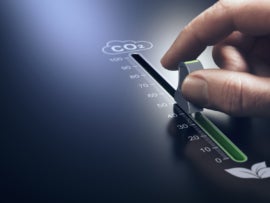 Hand using a slider to reduce CO2 emissions.