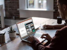 Persons working with MS Powerpoint on a laptop.